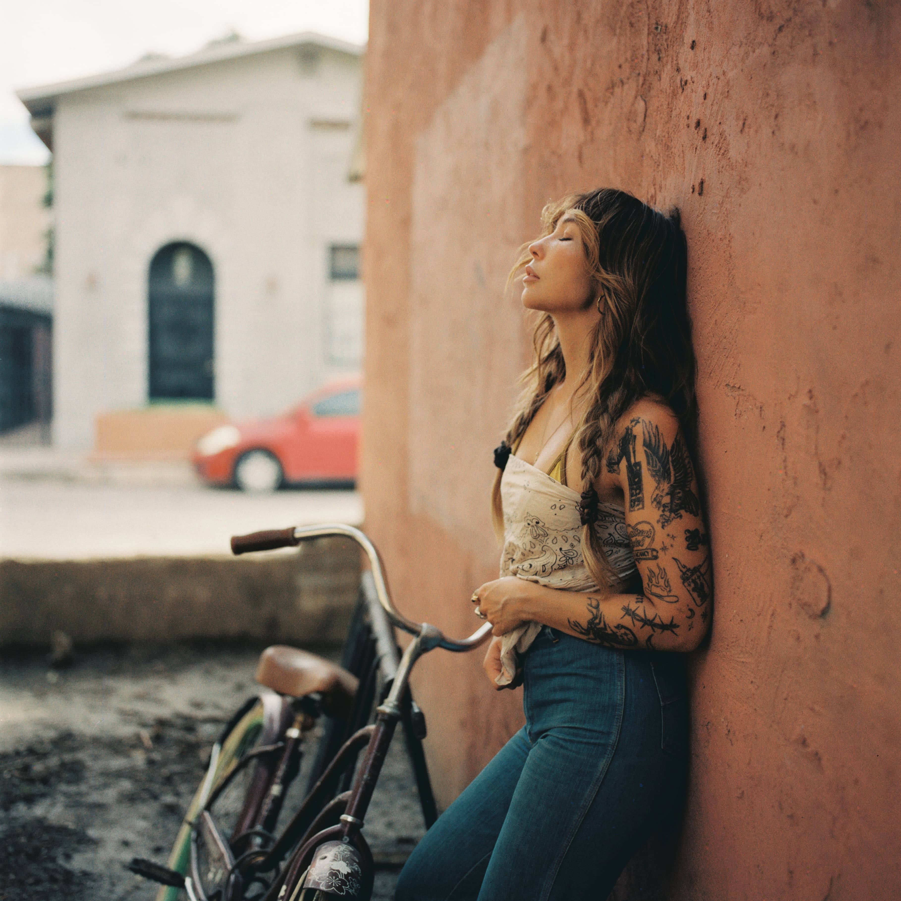 Film portrait of a woman beside a bicycle, photographed by Hannah Warren.