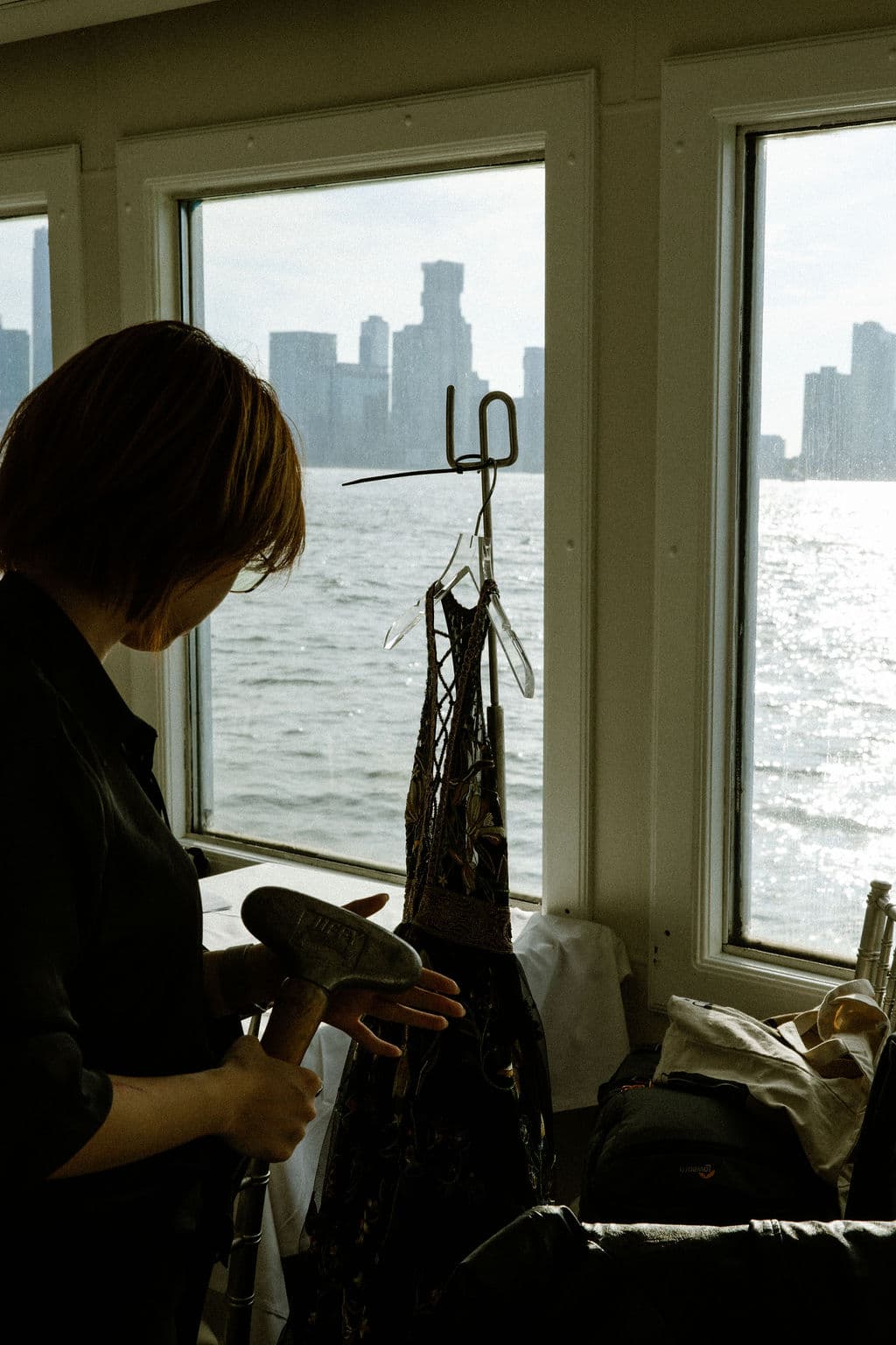 A wardrobe assistant steaming a Cucculelli Shaheen garment beside the venue windows.
