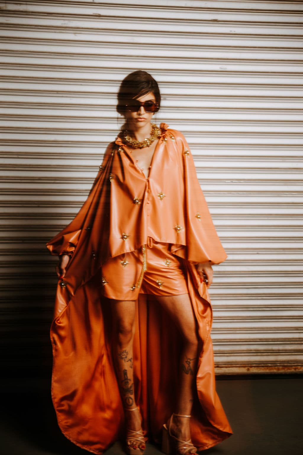 Motion-softened portrait of a model in a flowing orange look.