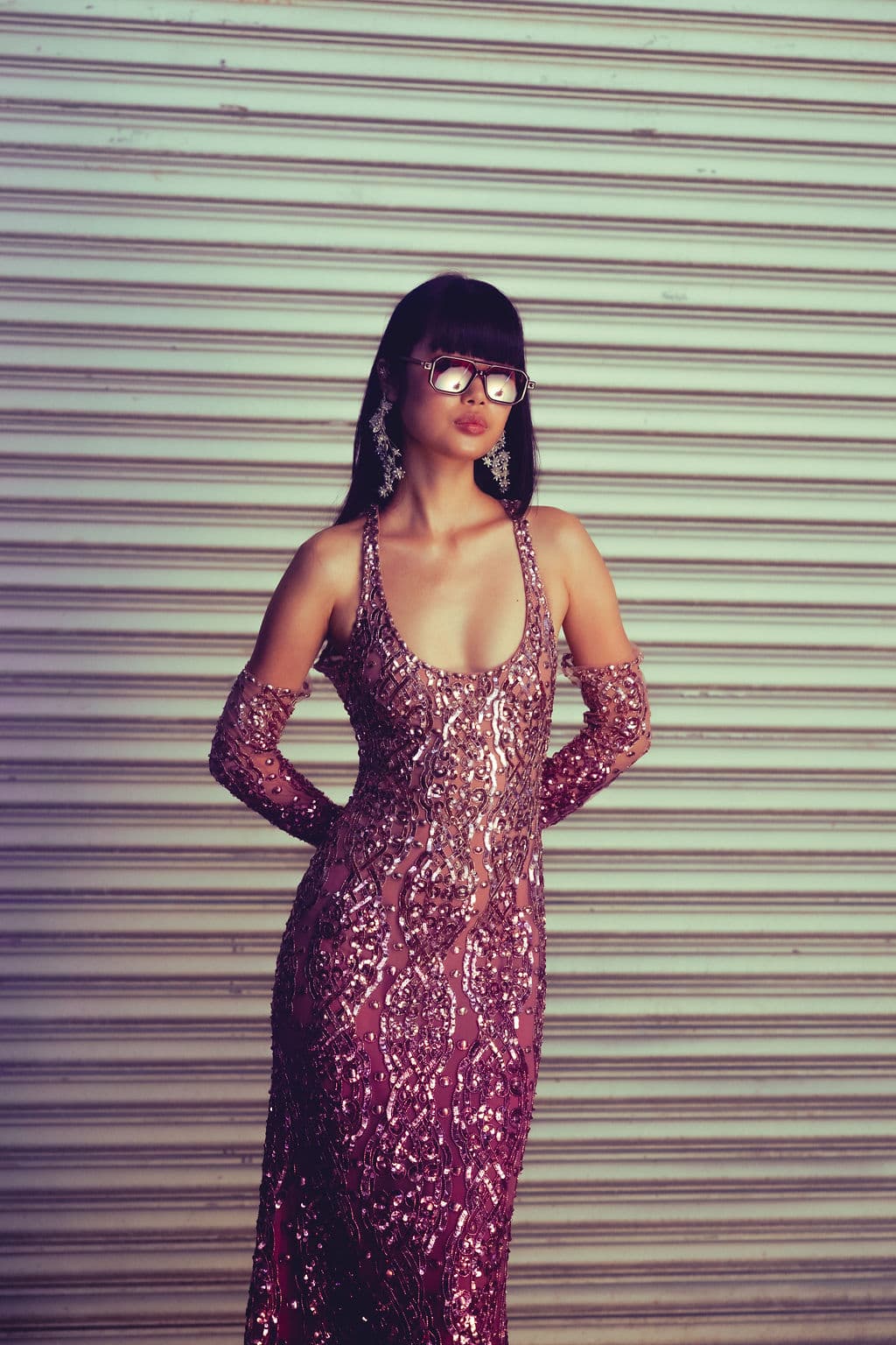 Model wearing a violet mirrored gown and oversized sunglasses.