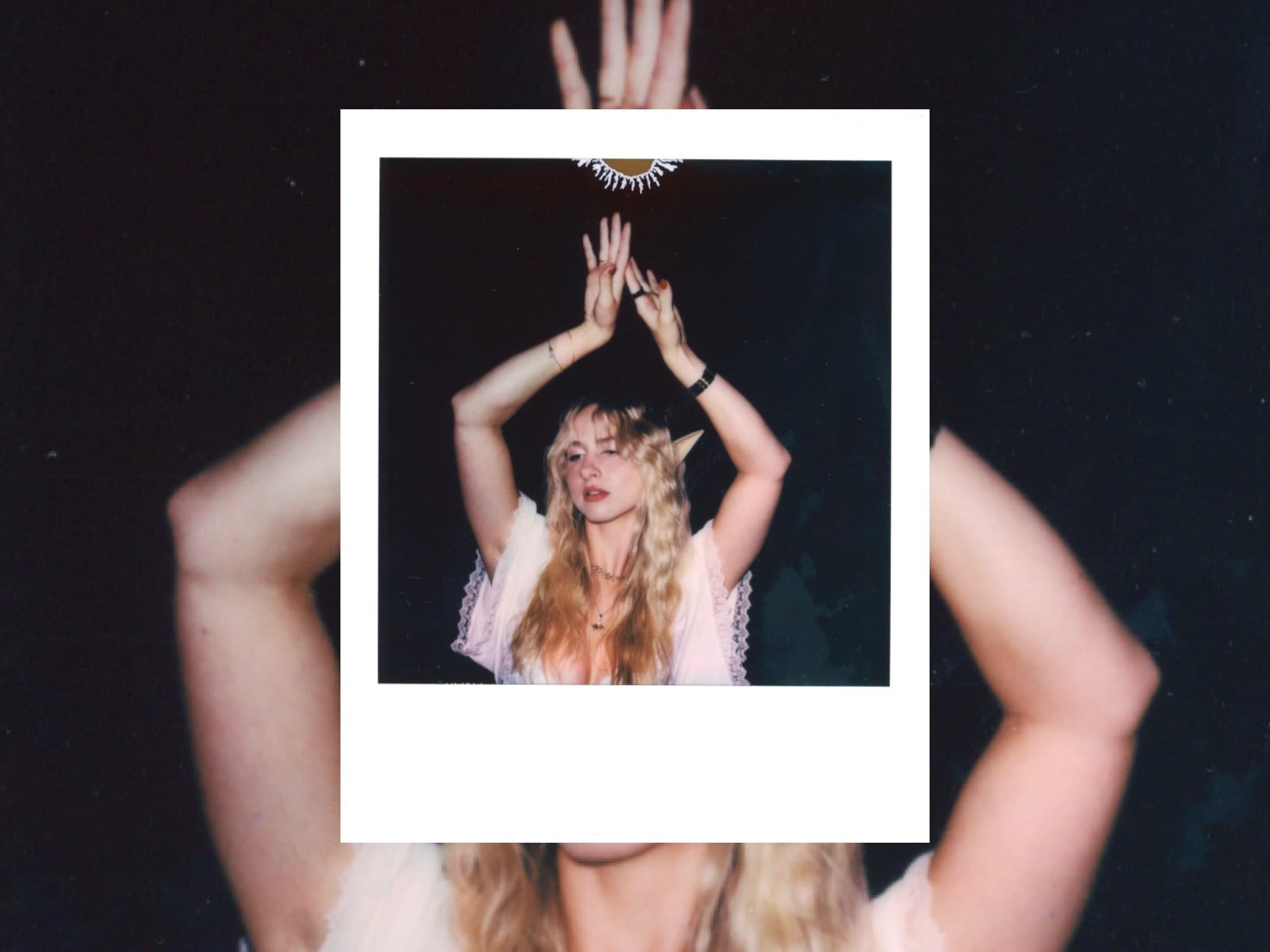 Hands holding up a Polaroid in front of the person it pictures.