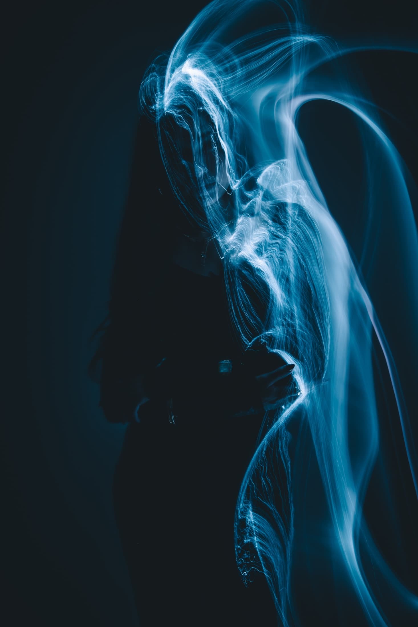 A figure traced by a pale ribbon of light against a dark field.