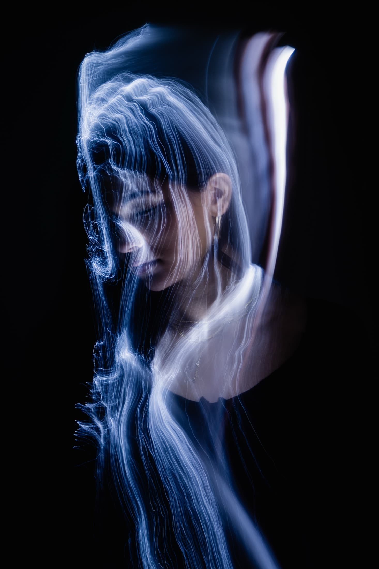 A figure in a blue-lit studio portrait.