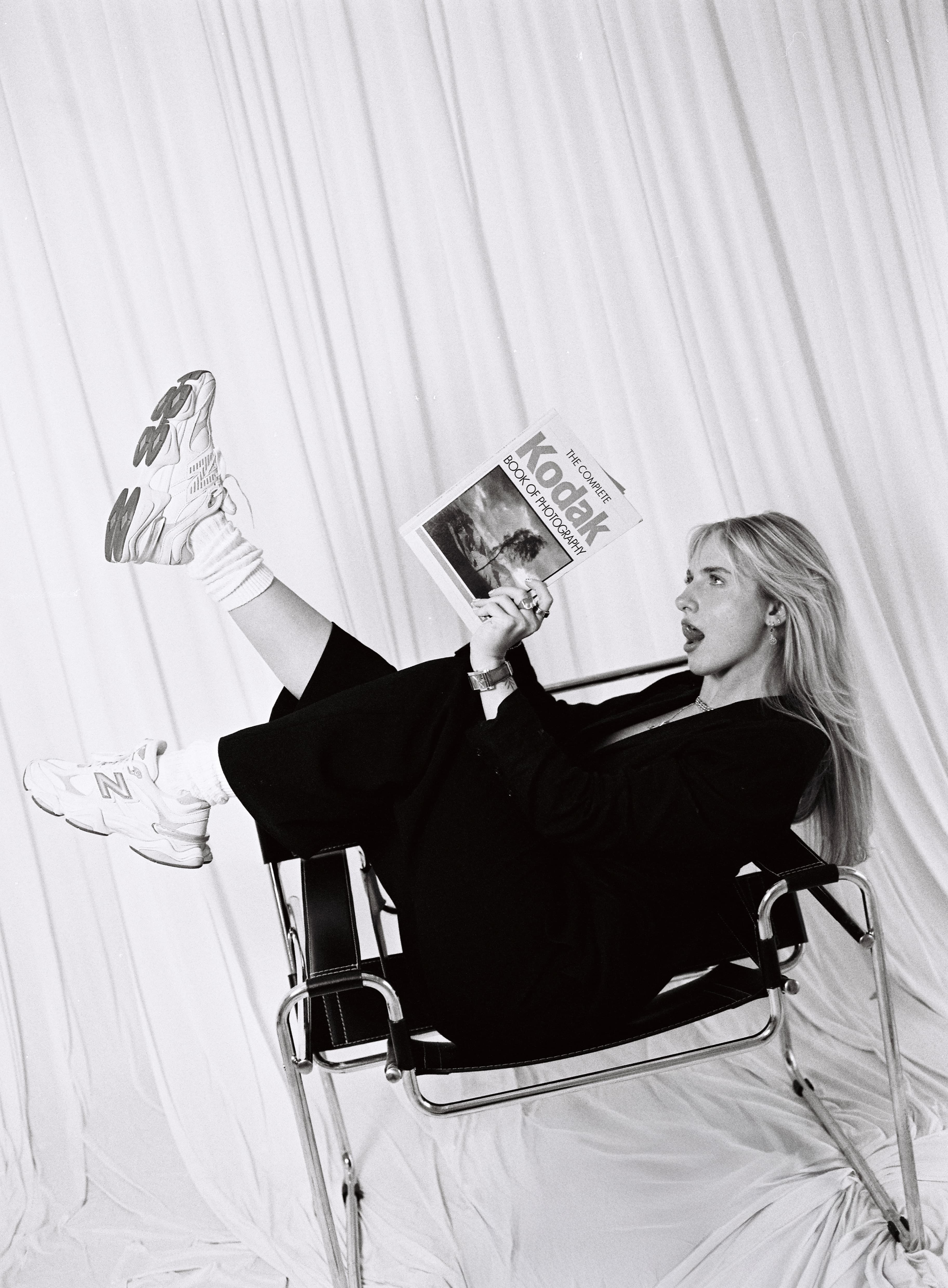 Black-and-white self-portrait of Hannah Warren reading a Kodak photography book.