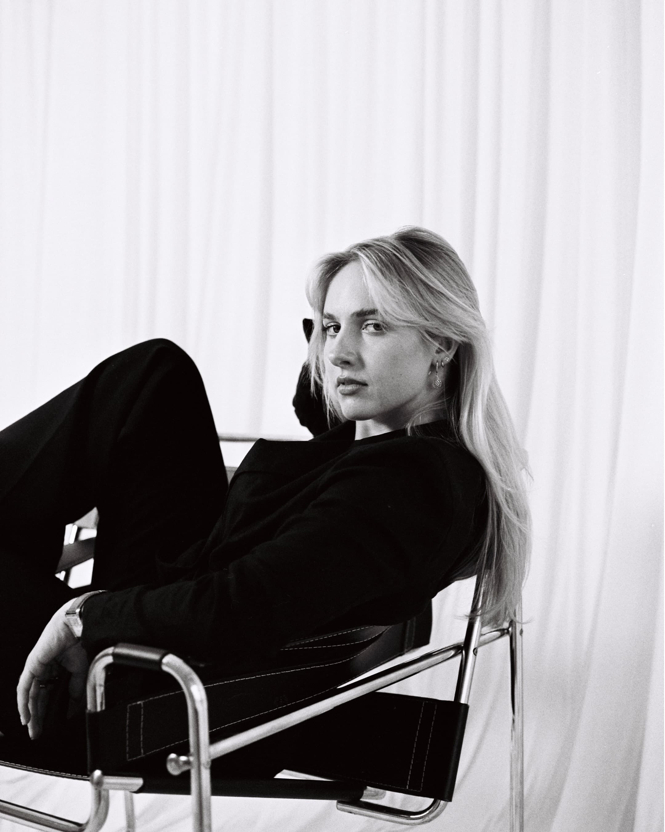 Black-and-white self-portrait of Hannah Warren reclining in a sling chair.
